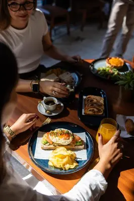a group of people sitting around a table eating breakfast at Pestana Porto - A Brasileira, City Center & Heritage Building in Porto