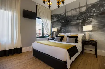 a bedroom with a large bed with a painting on the wall at the gallery Studios II in Porto