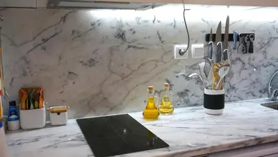 a kitchen counter with two bottles and knives on it at Casa da Andorinha, charm apt Porto Bolhão in Porto