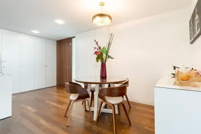 a kitchen with a table with chairs and a vase with flowers at Apartamento Qian Caves Gaia 2BR AC Free Parking in Vila Nova de Gaia