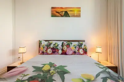 a bedroom with a bed with a floral bedspread at Apartamento Qian Caves Gaia 2BR AC Free Parking in Vila Nova de Gaia