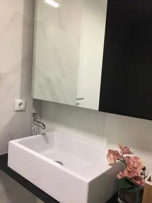 a white sink in a bathroom with a mirror at Apartamento Qian Caves Gaia 2BR AC Free Parking in Vila Nova de Gaia