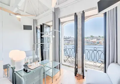 a living room with a view of the water at Oporto Street Fonte Taurina - Riverfront Suites in Porto