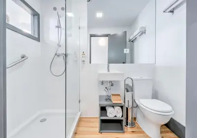 a white bathroom with a toilet and a shower at Oporto Street Fonte Taurina - Riverfront Suites in Porto