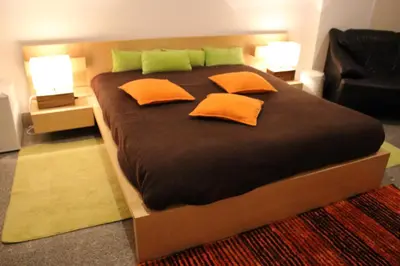a large bed with orange and green pillows on it at Flower's Downtown Porto in Porto