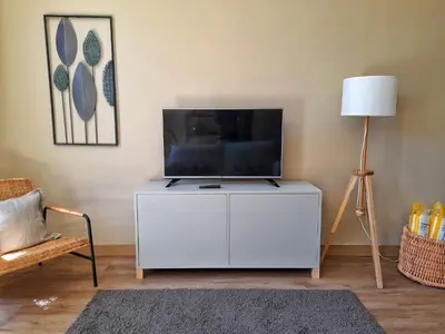 a living room with a flat screen tv and a couch at Flats 323 apartments in Porto