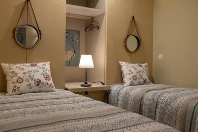 two beds in a room with two mirrors at HOMEinTOWN Almada - Downtown Elegant Apartment - Terrace AC & WIFI in Porto