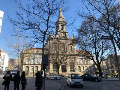 an old building with a clock tower on a city street at HOMEinTOWN Almada - Downtown Elegant Apartment - Terrace AC & WIFI in Porto