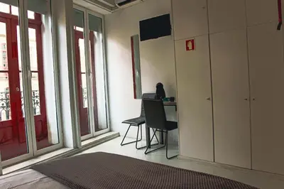 a room with a desk with a chair and windows at Hannah's Studios in Porto