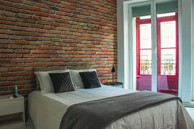 a bedroom with a brick wall and a bed at Hannah's Studios in Porto
