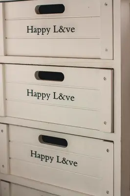 a stack of dresser drawers with happy love written on them at Hannah's Studios in Porto