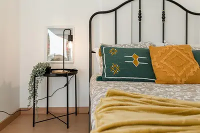 a bedroom with a bed with a green and yellow pillow at Oporto Bonjardim Residence in Porto