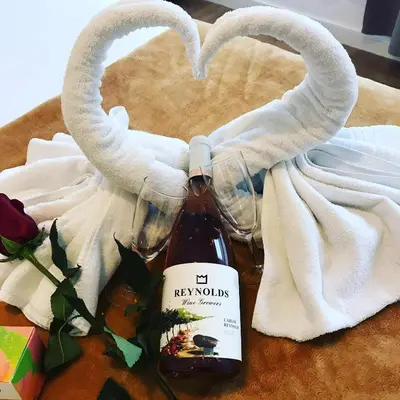 a bottle of wine and a heart shaped towel at Oporto Bonjardim Residence in Porto