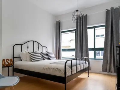 a bedroom with a bed and a large window at Oporto Bonjardim Residence in Porto