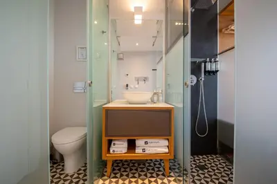 a bathroom with a sink and a toilet at Santa Catarina FLH Suites in Porto