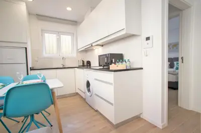 a kitchen with white cabinets and a table and chairs at Camões 691 Design Apartments by Porto City Hosts in Porto