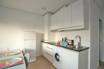 a white kitchen with a sink and a dishwasher at Camões 691 Design Apartments by Porto City Hosts in Porto