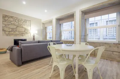 a living room with a table and chairs and a couch at OHH -S João apartments- Riverside in Porto