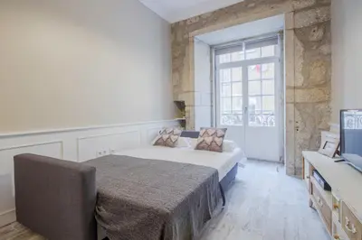 a bedroom with a bed and a large window at OHH -S João apartments- Riverside in Porto