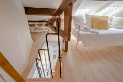 a attic bedroom with a bed and a staircase at BestVillas Casa do Rio in Vila Nova de Gaia