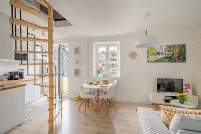a kitchen and a living room with a spiral staircase at BestVillas Casa do Rio in Vila Nova de Gaia