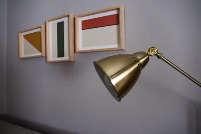 a gold lamp hanging on a wall with pictures at Impar Triplex House in Porto