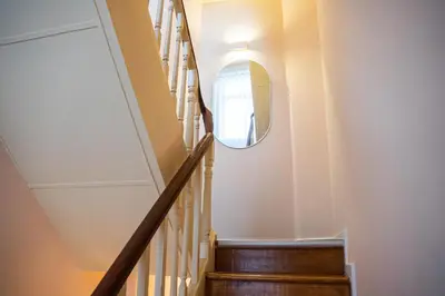 a hallway with a circular mirror on the wall at Impar Triplex House in Porto