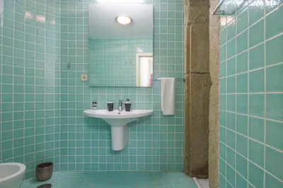 a blue tiled bathroom with a sink and a mirror at OHH - Ganesha studio- Oporto Center in Porto