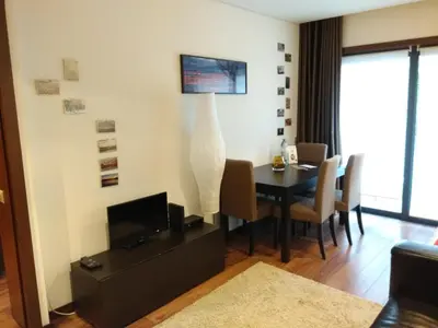 a living room with a dining room table with a television at PATH Dukes Apartment in Porto