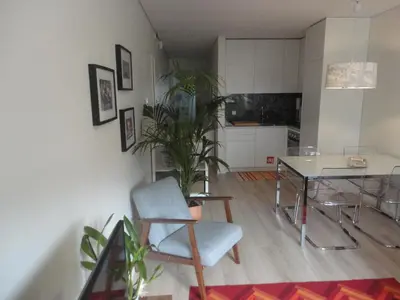 a living room with a table and chairs and a kitchen at Oporto Like Home II in Porto