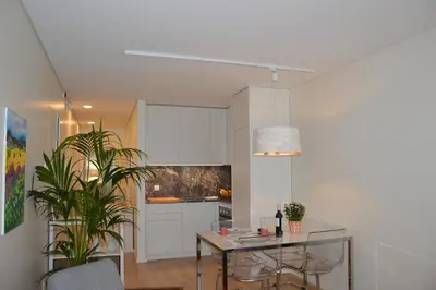a living room with a table and a kitchen at Oporto Like Home II in Porto