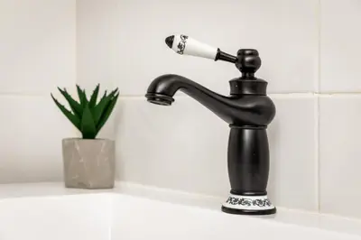 a black water faucet with a blow dryer at Porto Essence in Porto