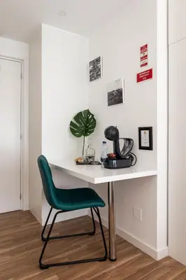 a white desk with a green chair in a room at Porto Essence in Porto