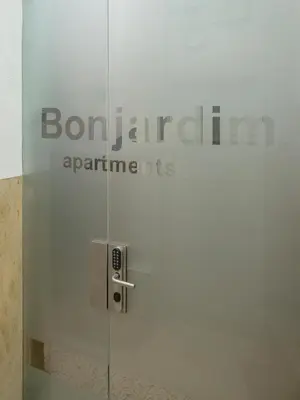 a glass door with a sign that reads bon jarlarmaarma at Porto Bonjardim Apartments in Porto
