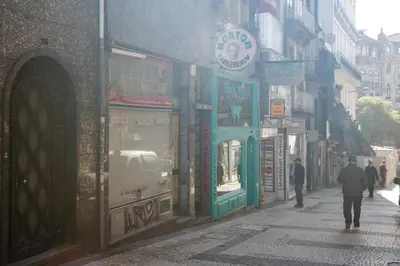 a man walking down a street in a city at Porto Bonjardim Apartments in Porto