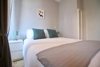a bedroom with a large white bed with blue pillows at D&S - Lapa 32 in Porto