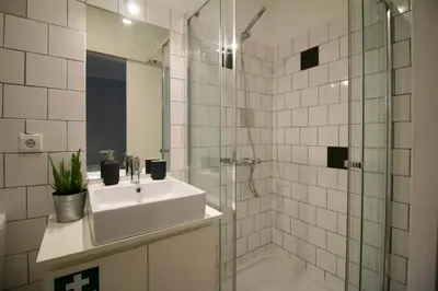 a white bathroom with a sink and a shower at D&S - Lapa 32 in Porto