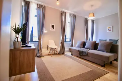 a living room with a couch and some windows at D&S - Lapa 32 in Porto