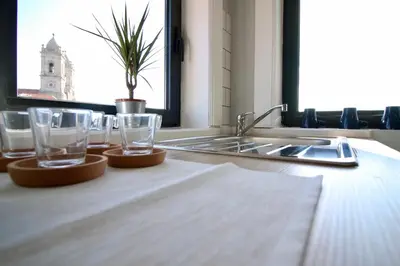 a kitchen counter with glasses and a sink and a window at D&S - Lapa 32 in Porto