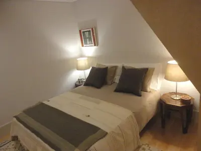 a bedroom with a bed with two lamps and two tables at Oporto Like Home IV - Mezzanine in Porto