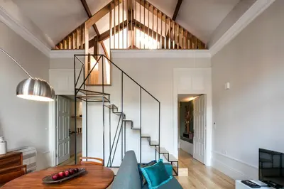 a living room with a staircase and a couch at Visconde Mezzanine in Porto