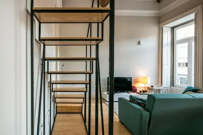 a loft bed in a living room with a couch at Visconde Mezzanine in Porto