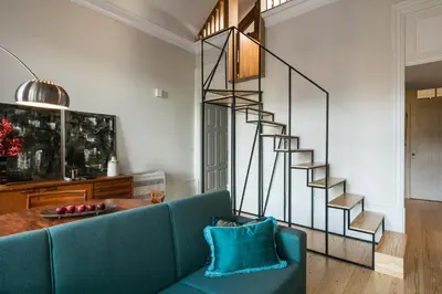 a living room with a blue couch and a spiral staircase at Visconde Mezzanine in Porto