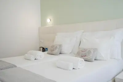 a white bed with four towels on top of it at Turista Da Trindade in Porto