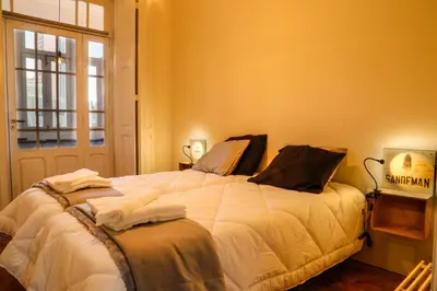 a bedroom with a bed with white sheets and a window at METRO APARTMENT in Porto