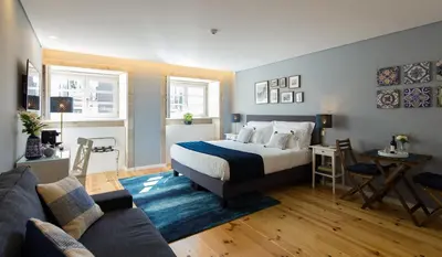 a bedroom with a bed and a living room at Virtudes City Lofts in Porto