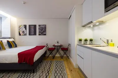 a bedroom with a bed and a kitchen with a sink at Virtudes City Lofts in Porto