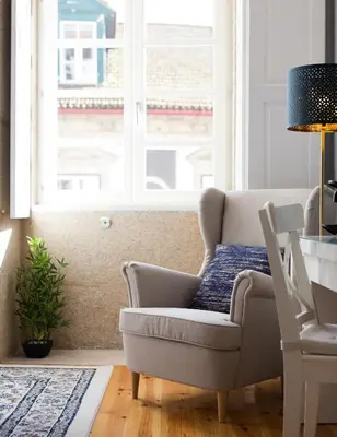 a living room with a chair and a window at Virtudes City Lofts in Porto