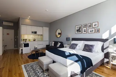a bedroom with a large bed and a living room at Virtudes City Lofts in Porto