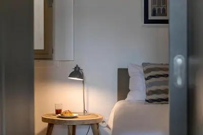 a bedroom with a table with a lamp and a bed at Modern 18th Century Flat in Porto